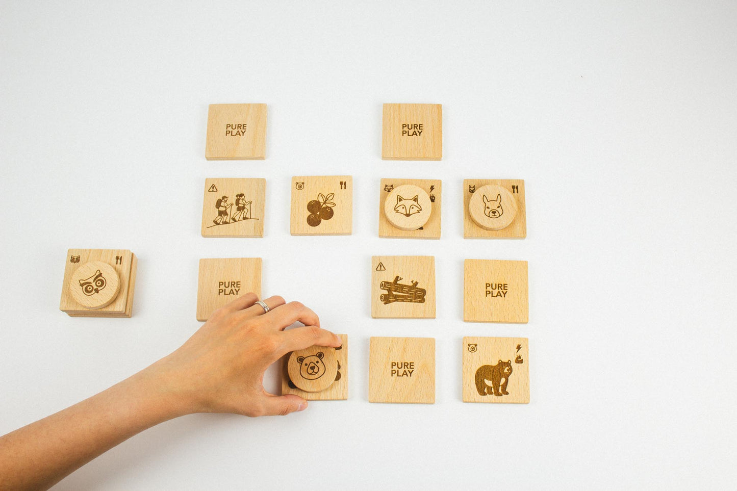 Hand placing wooden bear token during Forest Animal Rescue memory game by Pure Play – natural beechwood educational toy for kids.