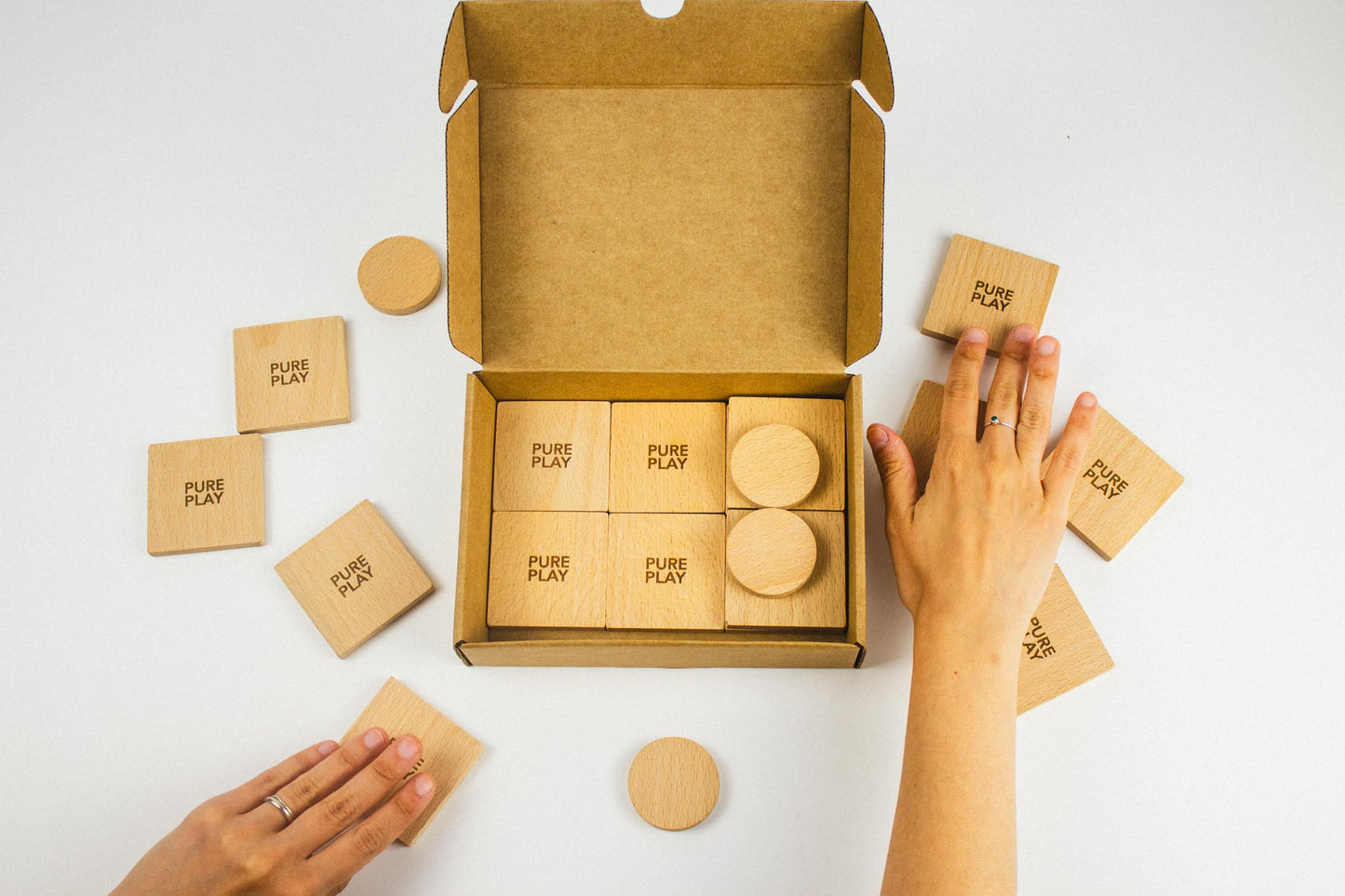 Pure Play Forest Animal Rescue game unboxing – hands organizing wooden cards and tokens in eco-friendly packaging.