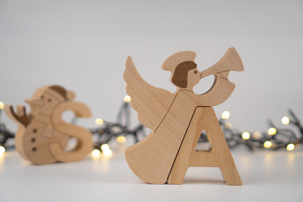 Wooden angel figurine with blurred Christmas lights in the background