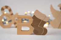 Wooden letters 'O' and 'B' on a light background with blurred decorative elements.