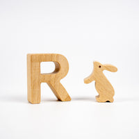 Wooden letter 'R' and wooden rabbit figure on a white background