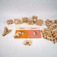 Wooden alphabet letters with illustrated book on a white background