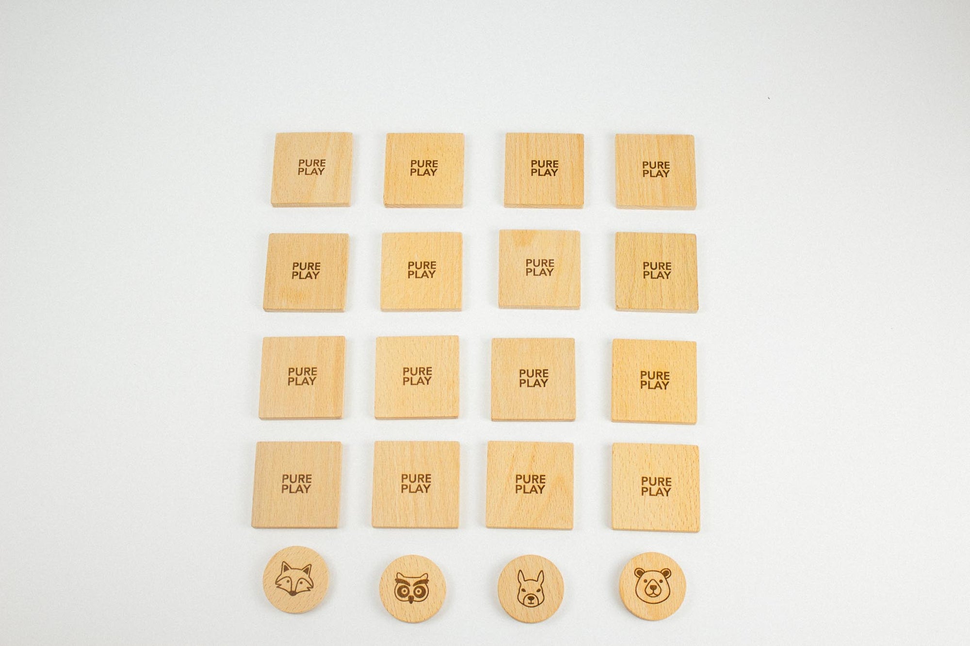 Top-down view of Pure Play wooden memory game – forest-themed cards arranged face-down with animal tokens ready to match.