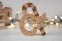 Wooden candy cane ornament with a bow on a blurred light background