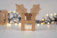 Wooden letter 'H' with holly leaves on a blurred light background
